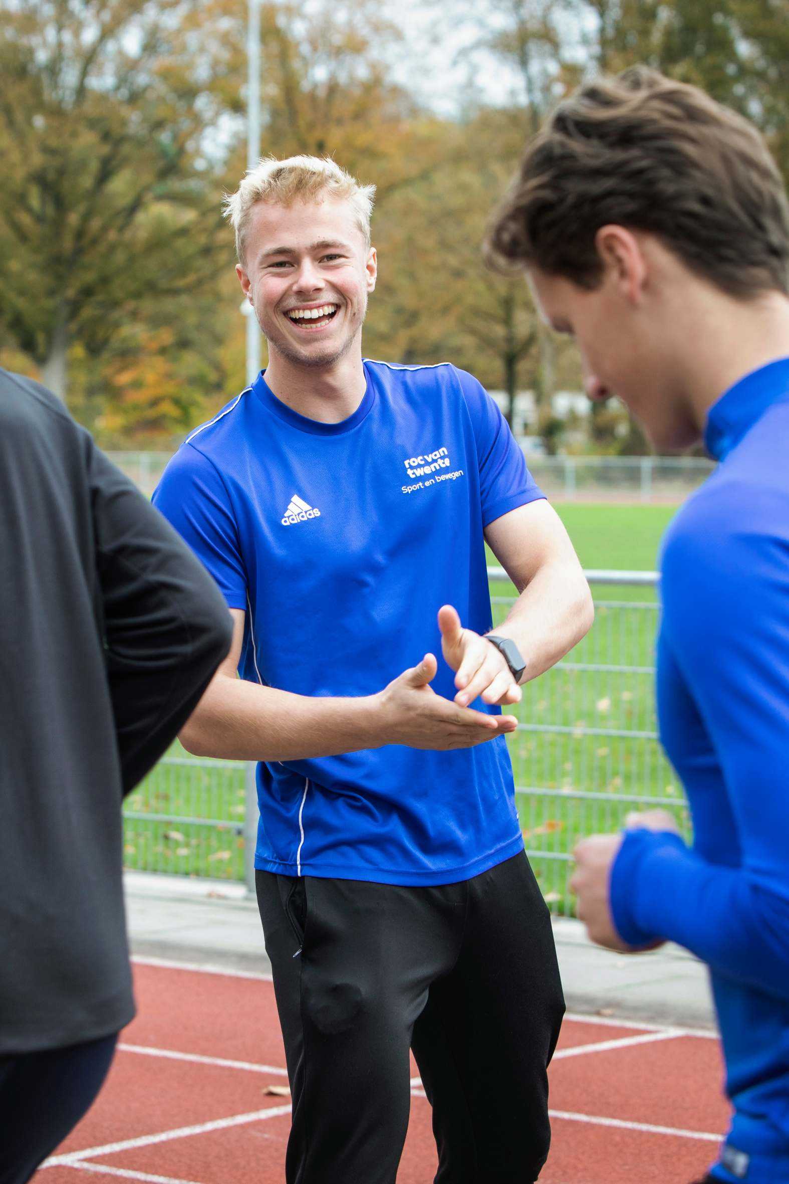 Practoraat sociaal veilige sport roc van twente instructeur die iemand aanmoedigt op hardloopbaan